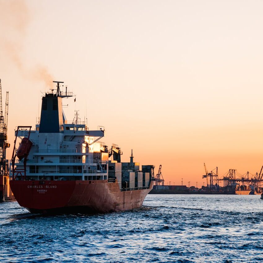 Stunning sunset view of cargo ships and cranes at the Port of Hamburg, epitomizing global trade and logistics.